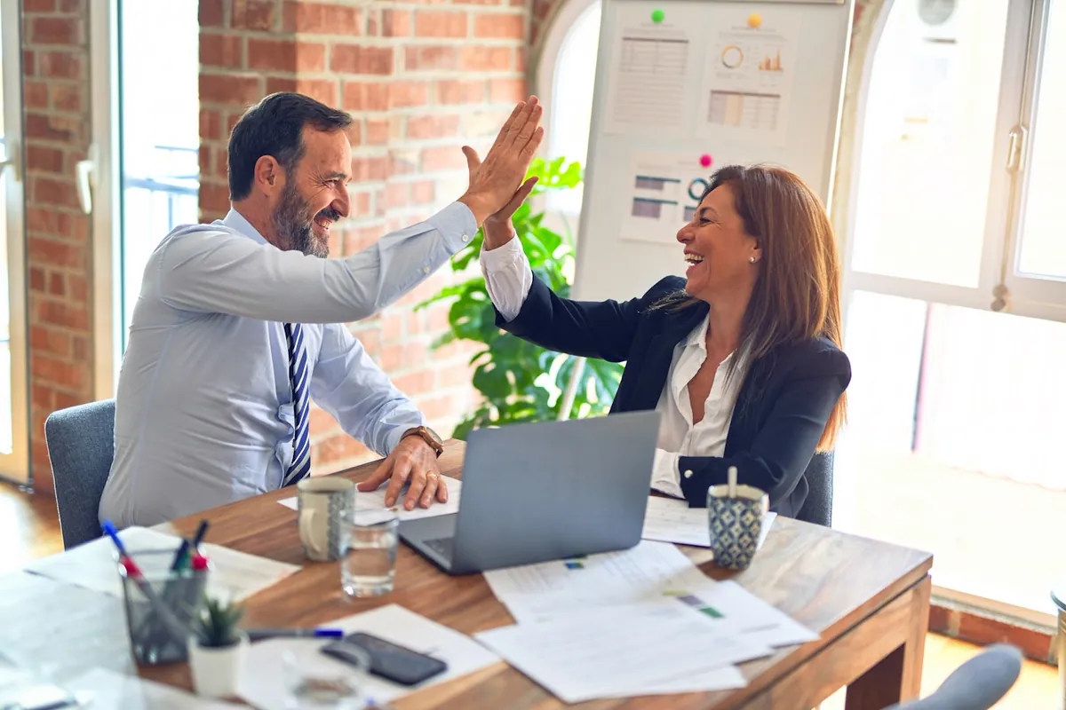 Two partners celebrating a finished deal at the office